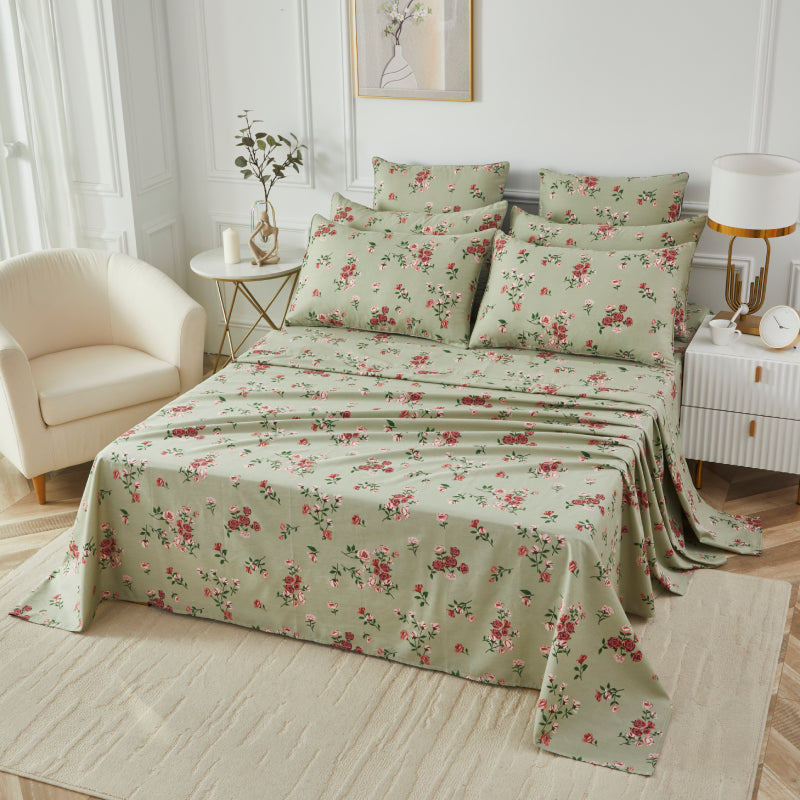 Bed with red floral patterned bedding in a bedroom setting.