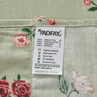 Fabric label with care instructions on a red floral patterned fabric