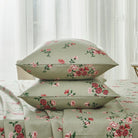 Bed with red floral patterned bedding and pillows on a neutral background