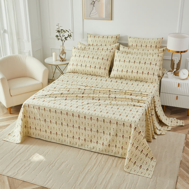 Bed with red rose patterned bedding in a bedroom setting.
