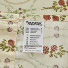 Fabric label with care instructions on a red rose floral patterned fabric