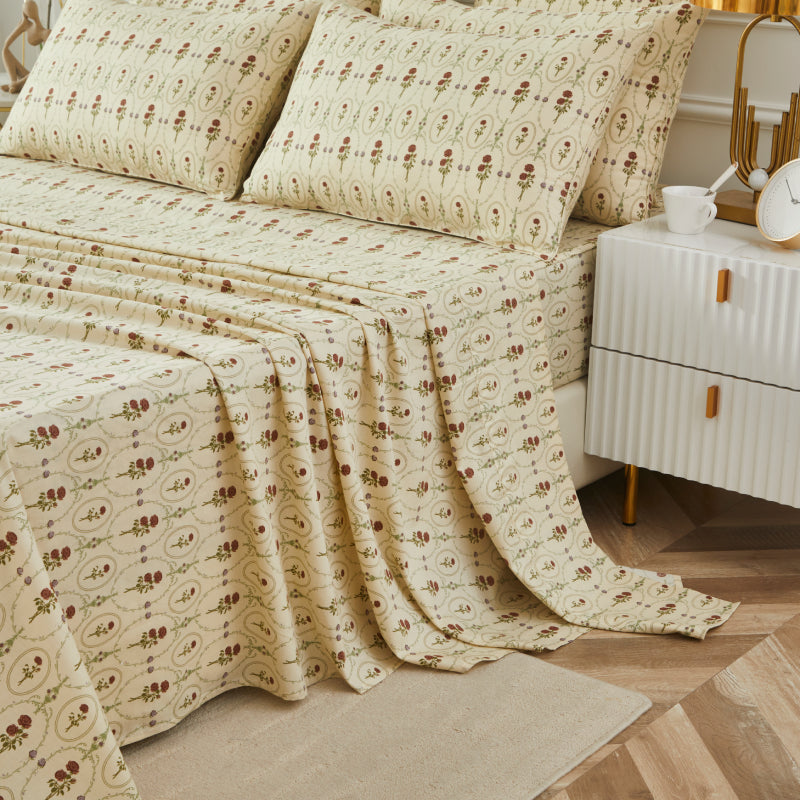 Bed with red rose patterned bedding in a bedroom setting