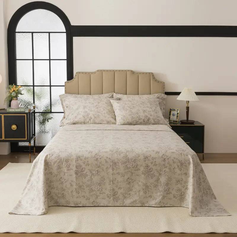Bed with red floral patterned bedding in a bedroom setting.