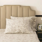 Bed with red floral patterned bedding and pillows on a neutral background