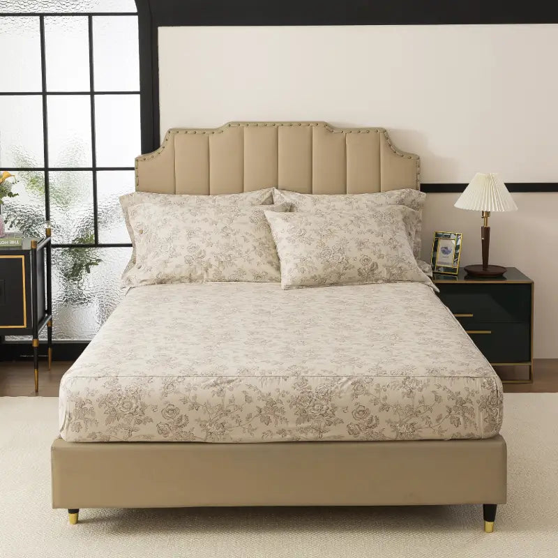 Bed with red floral patterned bedding in a bedroom setting.