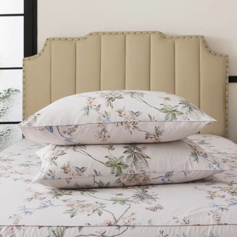 Bed with red floral patterned bedding and pillows on a neutral background