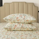 Bed with red floral patterned bedding and pillows on a neutral background